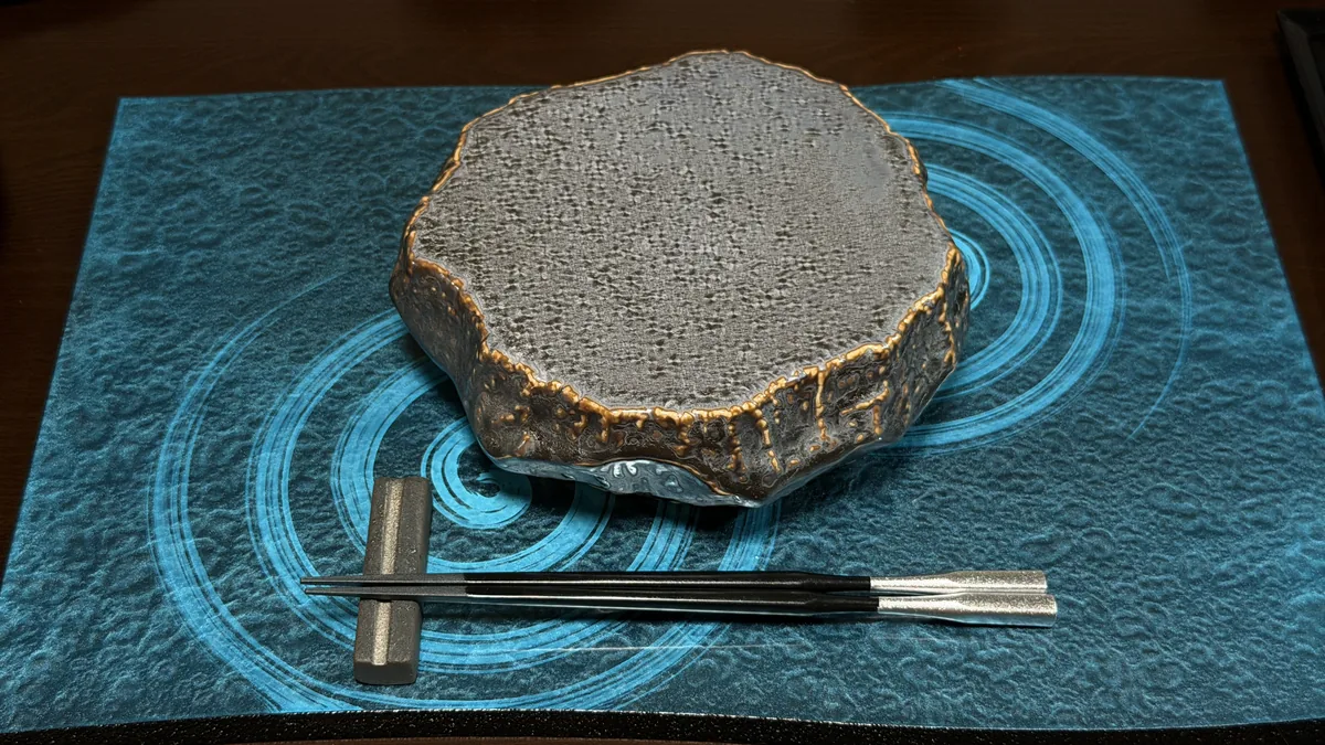 水紋柄の敷物に岩のような焼物の器を置いた、水紋に浮かぶ岩をイメージしたサンプル