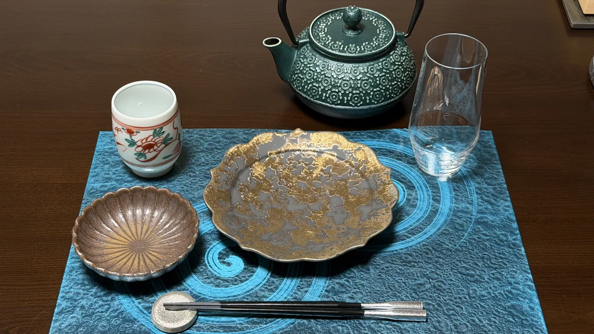 鉄瓶・グラス・赤絵の湯呑・金銀の皿・小鉢を並べた、蕎席 雅山の開店時の器