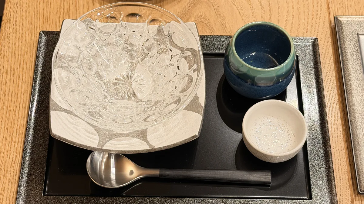 ガラスの器と紺の小鉢を黒い盆に置いた、蕎席 雅山の夏の器のセッティング
