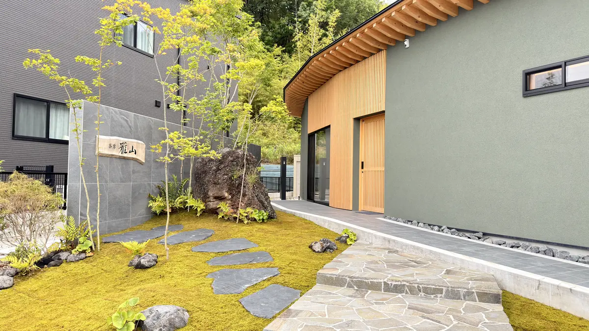 蕎席 雅山の外観。苔の庭と飛び石の先に、木の軒と緑の壁の建物が建つ蕎麦懐石の店